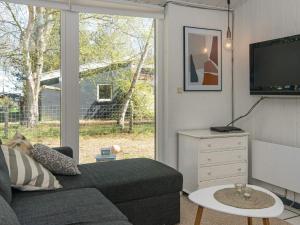een woonkamer met een bank en een tv bij 8 person holiday home in rsted in Kare