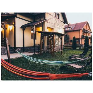 a hammock in the grass in front of a house at House of Seasons in Bran