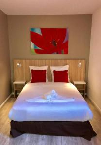 ein Schlafzimmer mit einem großen weißen Bett mit roten Kissen in der Unterkunft Neoresid - Résidence Saint Germain in Amiens