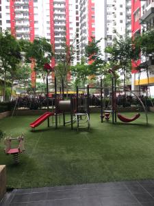 een park met een speeltuin met rode schommels bij Main Place Resort Family Suite in Subang Jaya