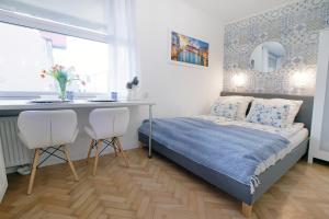 ein kleines Schlafzimmer mit einem Bett, einem Tisch und Stühlen in der Unterkunft Duarte Apartamenty Kołłataja Wrocław in Breslau