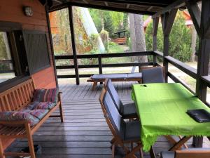 a screened in porch with a green table and chairs at Domek nad jeziorem Głębokie in Głębokie
