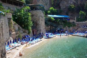 a beach with chairs and people in the water at Marka Hotel in Antalya