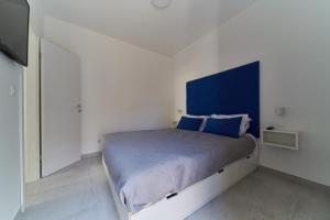 een slaapkamer met een groot bed met een blauw hoofdeinde bij Villa Baronessa in Zadar