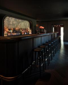 un bar con taburetes en una habitación oscura en Château de Vignée, en Rochefort