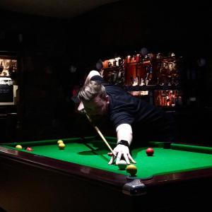 a man playing pool with a cue on a pool table at Castle Inn in Newport Pembrokeshire