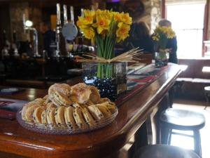 - une table avec des pâtisseries et un vase de fleurs dans l'établissement Castle Inn, à Newport