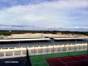 un edificio con un campo da tennis di fronte ad esso di Gran Hotel del Coto a Matalascañas