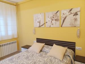 a bedroom with a bed with three pictures on the wall at Apartamentos Querol in Valderrobres