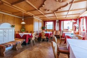 ein Restaurant mit Tischen und Stühlen in einem Zimmer in der Unterkunft Residence Speckerhof in Meransen