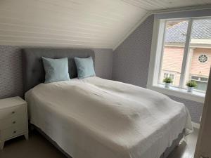 1 dormitorio con 1 cama blanca grande y 2 almohadas en Old town boutiqe apartments/ Gamle Lærdalsøyri boutique leiligheter en Lærdalsøyri