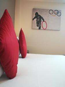 two red pillows sitting on top of a bed at Britannia Study Hotel in Brighton & Hove