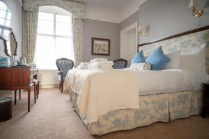 a bedroom with a large bed with blue and white pillows at Coul House Hotel in Contin