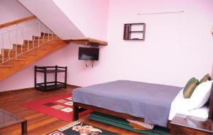 a bedroom with a bed and a staircase at Lotus The Cottages in Madikeri