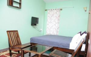 sypialnia z łóżkiem oraz szklanym stołem i krzesłami w obiekcie Lotus The Cottages w mieście Madikeri