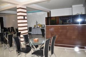 a dining room with a glass table and chairs at Hotel Briston in Cochabamba