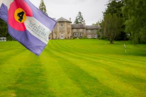 una bandera está volando delante de una casa en Coul House Hotel, en Contin