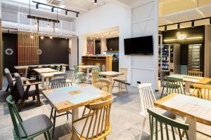 a restaurant with tables and chairs and a tv at Hotel J.J. Darboven in Rumia