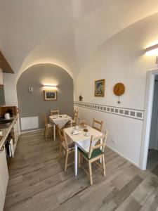 un comedor con mesas y sillas en la cocina en B&B Corte Santa Maria en Rovereto