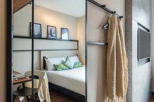 a guest room with a bed and a mirror at ibis Brussels Centre Chatelain in Brussels