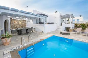 a villa with a swimming pool and a patio at Mykonos Psarrou villas for 18 people in Mýkonos City