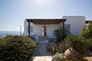 a small white house with a wooden roof at Mykonos Psarrou villas for 18 people in Mýkonos City