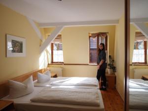 a woman standing in a room with three beds at Jugendgästehaus Cottbus in Cottbus