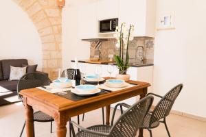 a dining room with a wooden table and chairs at Cava Rossa in Favignana