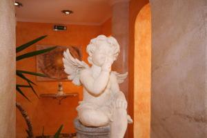 a white statue of a cherub sitting on a pedestal at Wellness-Pension Jagahütt'n in Schladming
