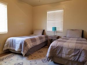 two beds in a room with two windows at Quiet Desert Oasis off Swan Rd in Tucson