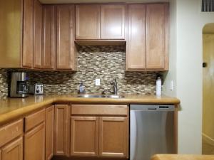 a kitchen with wooden cabinets and a dishwasher at Quiet Desert Oasis off Swan Rd in Tucson