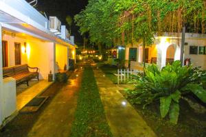 an empty street at night with a bench and buildings at Hotel Nawathana in Matara