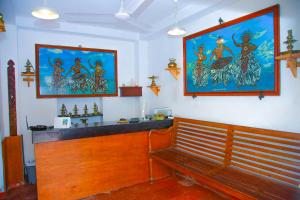 a bench in a room with two pictures on the wall at Hotel Nawathana in Matara