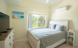 a bedroom with a bed and a window at Villa Turkuaz in Providenciales +33 photos
