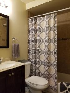 La salle de bains est pourvue de toilettes et d'un rideau de douche. dans l'établissement Quiet Desert Oasis off Swan Rd, à Tucson