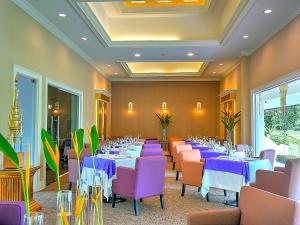 une salle à manger avec des tables et des chaises violettes dans l'établissement MonPanaNont Wellness Resort & Spa - SHA Extra Plus, à Mae Taeng
