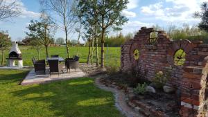 a brick wall with chairs and a table in a yard at Domki U Wojtka w Niechorzu in Niechorze