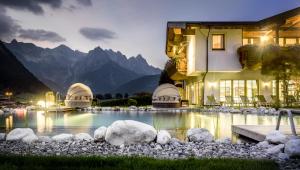 a house with a swimming pool at night with mountains at Adults Only Boutique-Hotel Unterlechner in Sankt Jakob in Haus