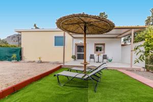 a patio with a chair and an umbrella at Manolis Studio in Kolymbia