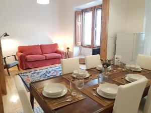 een eetkamer met een tafel en een rode bank bij Sintra Chalet in Sintra