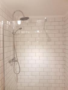 uma casa de banho com um chuveiro de azulejos brancos e uma cabeça de chuveiro. em Sintra Chalet em Sintra