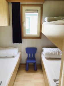 a blue chair in a room with two bunk beds at Chalet Kocky in Midsland