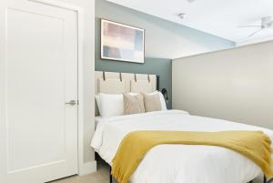 una camera da letto con un grande letto bianco con una coperta gialla di Sonder Belcourt a Nashville