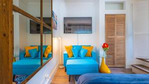 Habitación con sofá azul y almohadas amarillas. en Lemon Cottage - At Orange Hill, en Nassau