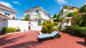 eine Bank auf einer Terrasse vor einem Haus in der Unterkunft Lemon Cottage - At Orange Hill in Nassau