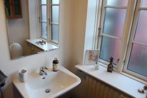 a bathroom with a sink and a mirror at Købmandsgården i Grundfør in Hinnerup +13 photos
