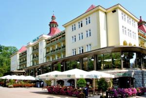 un gran edificio con mesas y sombrillas blancas en Wielka Pieniawa en Polanica-Zdrój