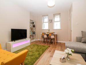 a living room with a television and a couch at Cove Cottage in Torquay