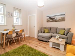 een woonkamer met een bank en een tafel bij Cove Cottage in Torquay