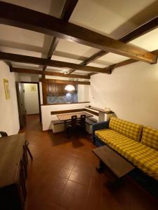 uma sala de estar com um sofá amarelo e uma mesa em Apartment 89 Residence Palace 2 em Sestriere